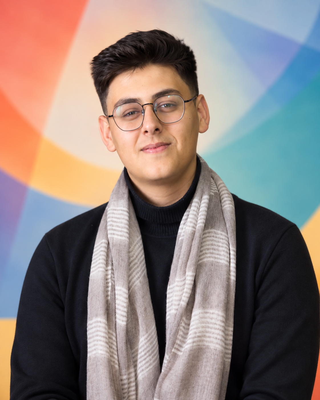 A person wearing glasses and a scarf sits in a soundproof room with a microphone and an acoustic guitar visible.