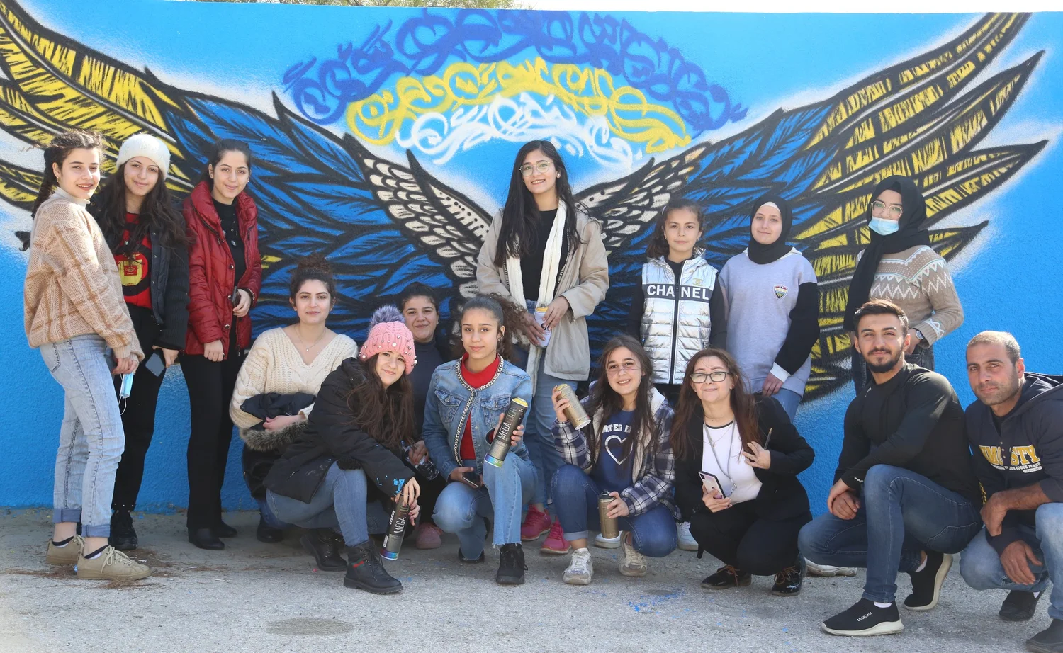 Peace of Art participants in front of a peace mural