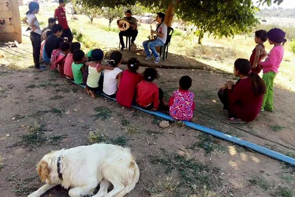 Refugee children listening to live music during Sing for Peace