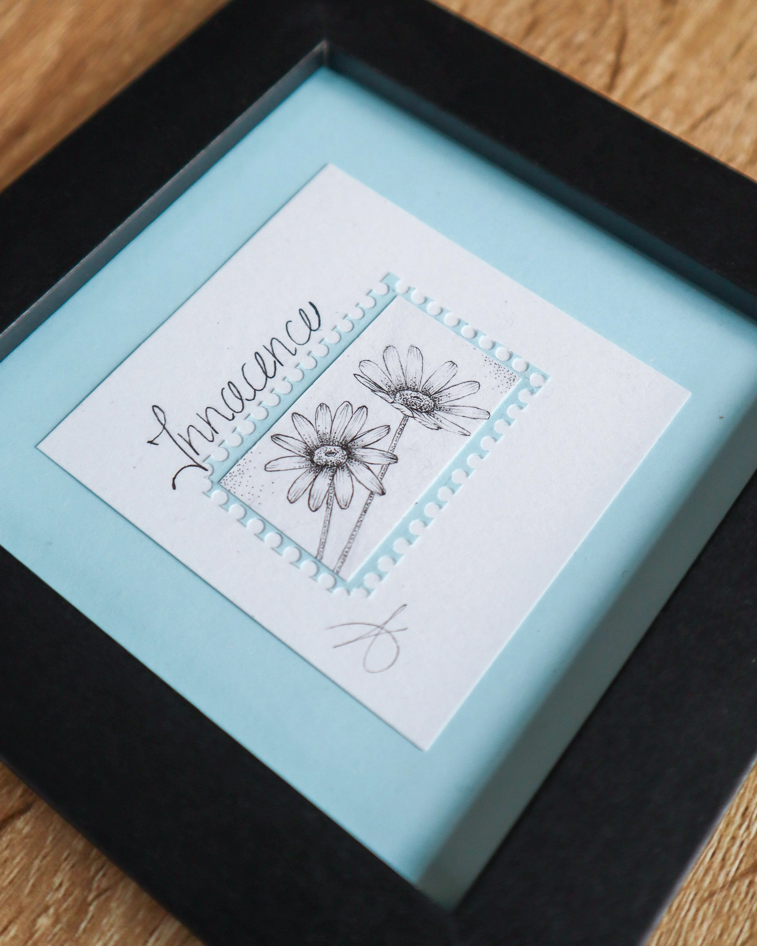 Timbre floral Marguerite avec le mot Innocence en pointillisme au feutre noir – œuvre originale 10×10 cm
