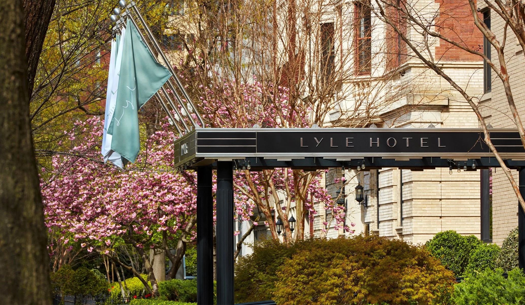 Entrance to Lyle Hotel in Washington DC on a tree lined street with pink blossoms