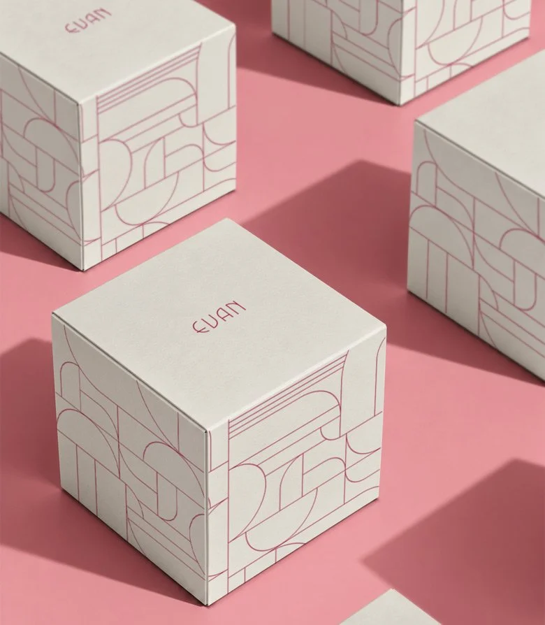 white take away cake boxes with a magenta Evan Bakery logo on the lid and art deco pattern around the sides