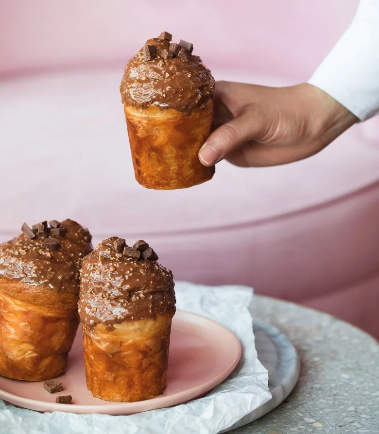 chocolate cakes being placed onto a pink plate by hand