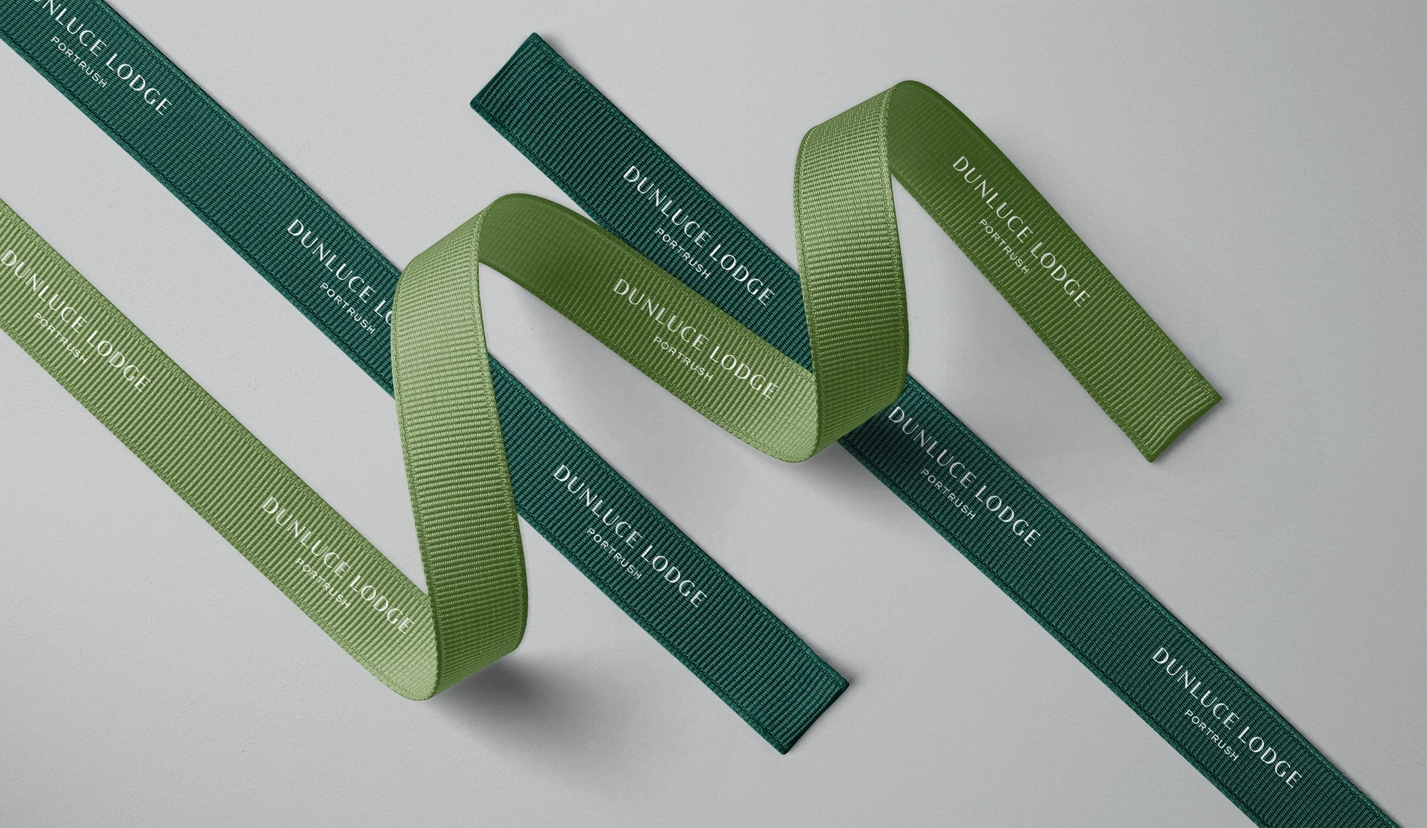 ribbons in two shades of green, part of the the print collateral for Dunluce Lodge hotel branding by Colt