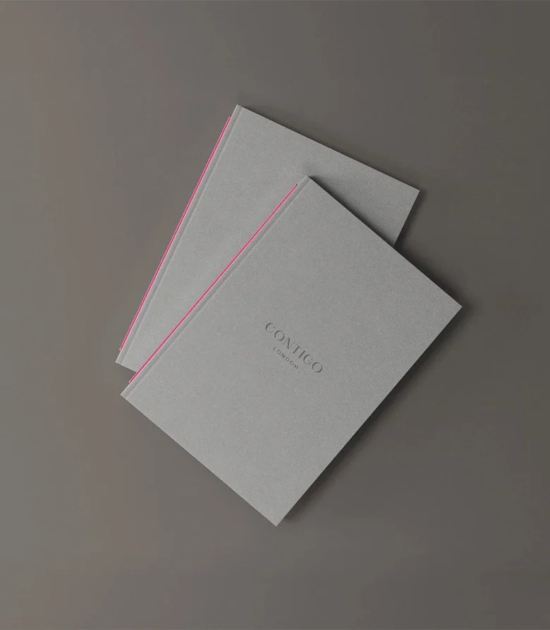 Grey menu folders with pink fabric bind, created by Colt as part of the brand identity for Contigo restaurant in London