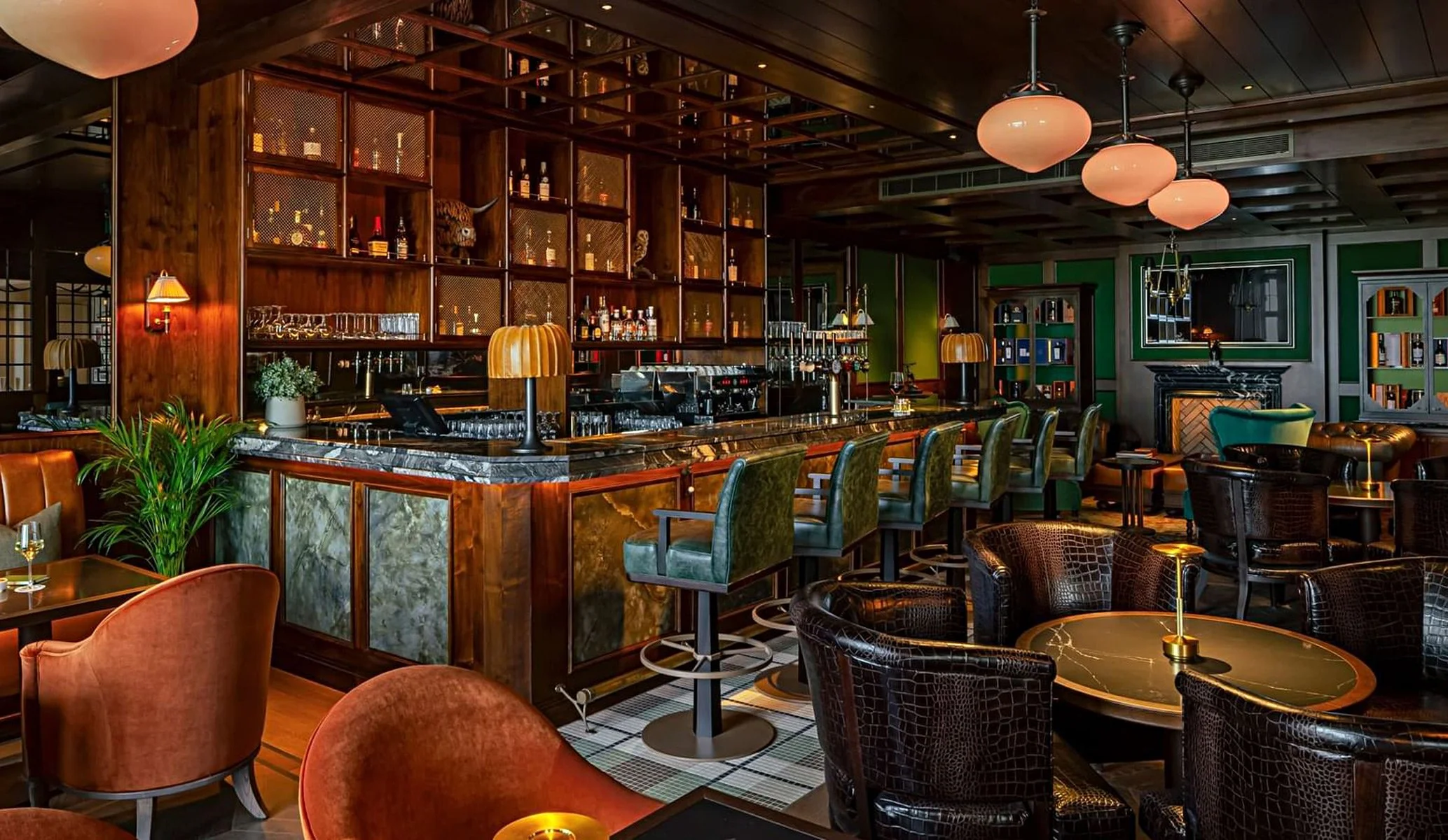 Bow Butts whiskey bar interior featuring green leather seats and low lighting