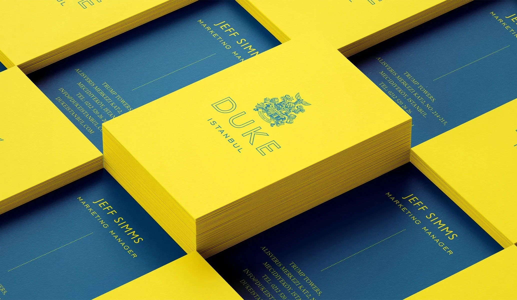 Stacks of business cards in yellow and blue for Duke restaurant in Istanbul, created as part of the brand identity by Colt