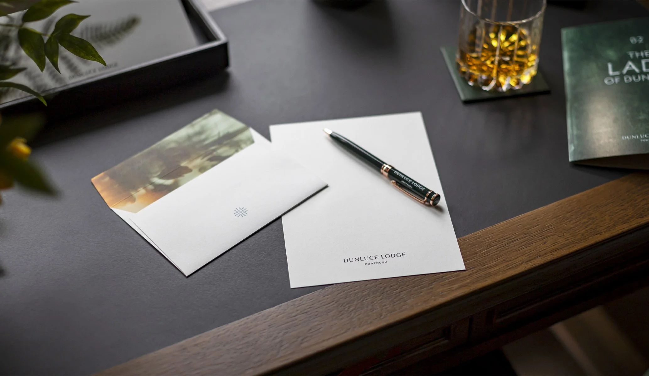 notebook, pen and envelope produced as part of the brand identity for Dunluce Lodge designed by Colt branding agency, London