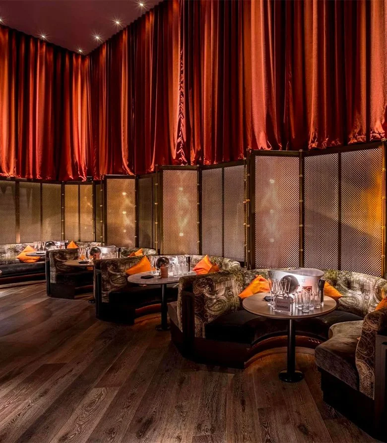 Interior design featuring draped curtains and booths at 100 Wardour St