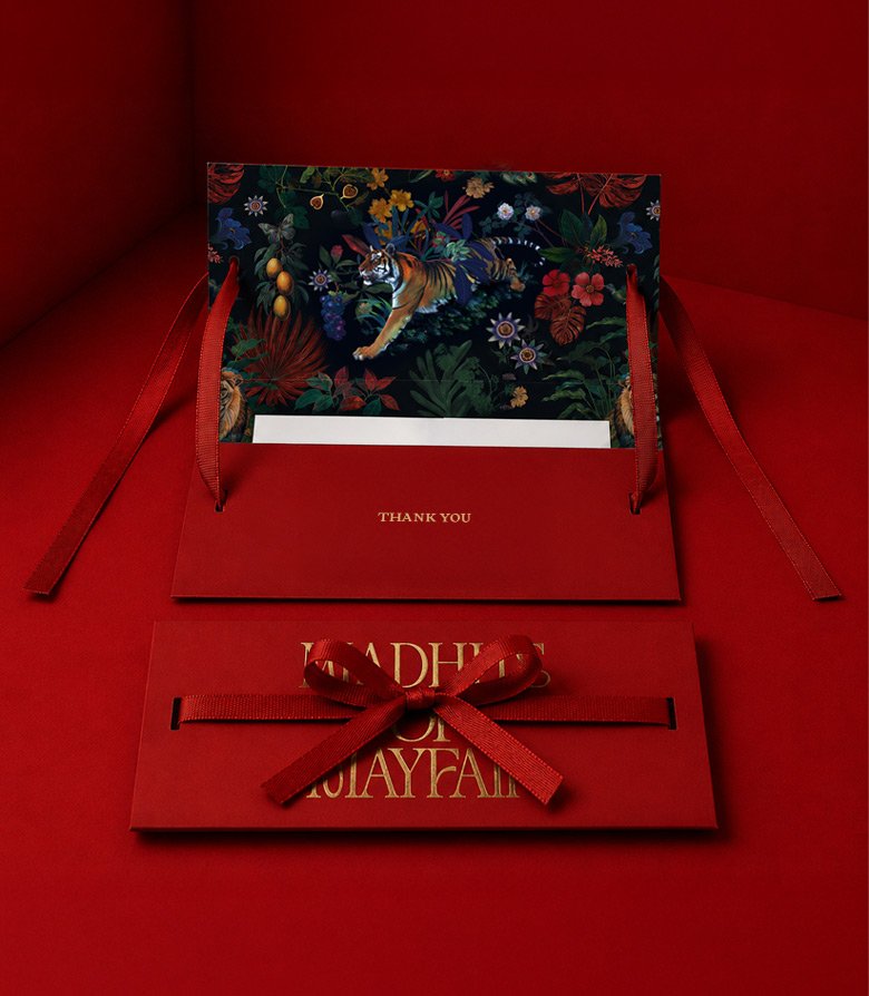 red bill holder with red ribbon seal and gold foil blocked logo on a red background