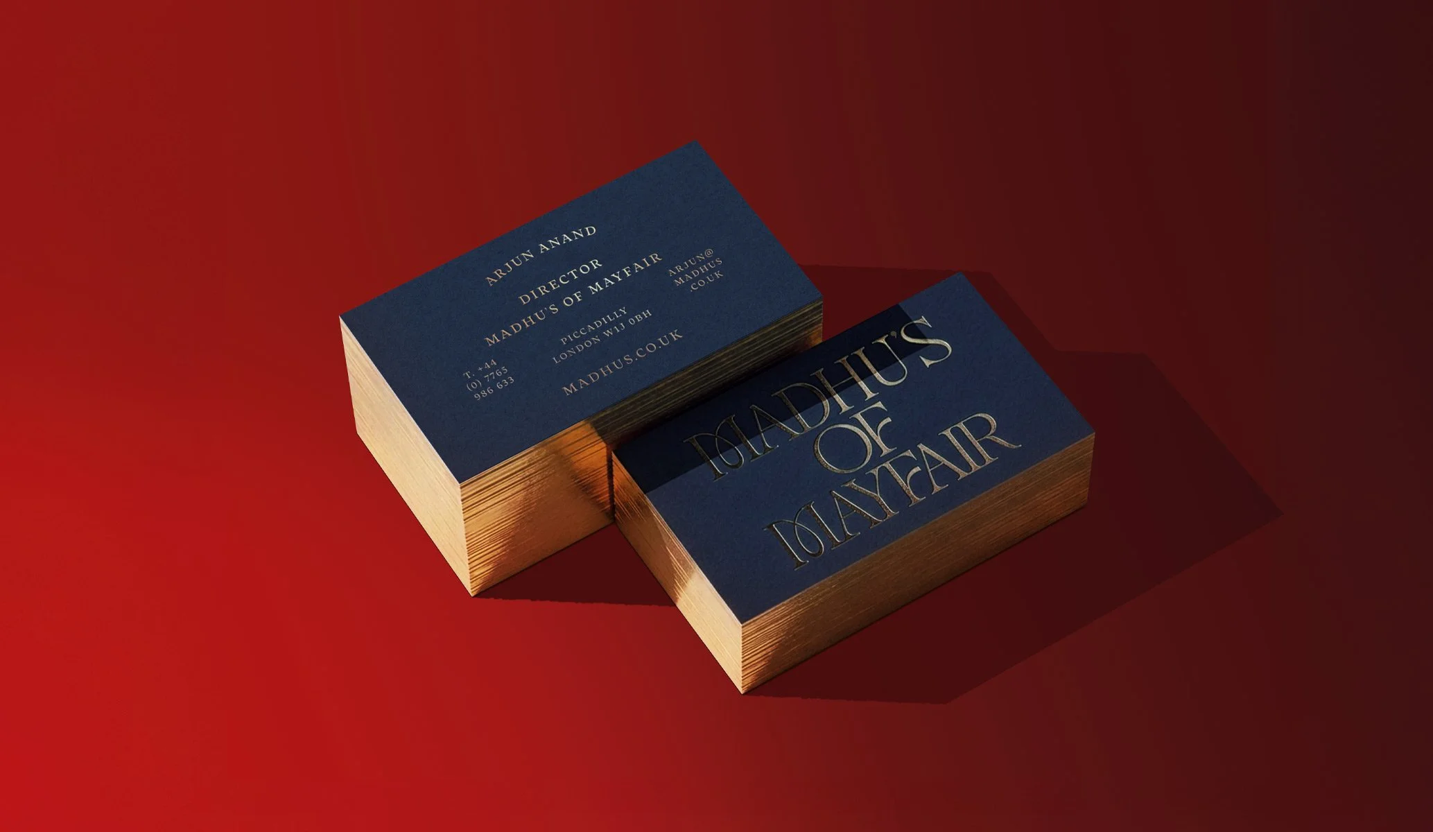 blue business cards with gold foil block Madhu's of Mayfair logo and gold gilt edges
