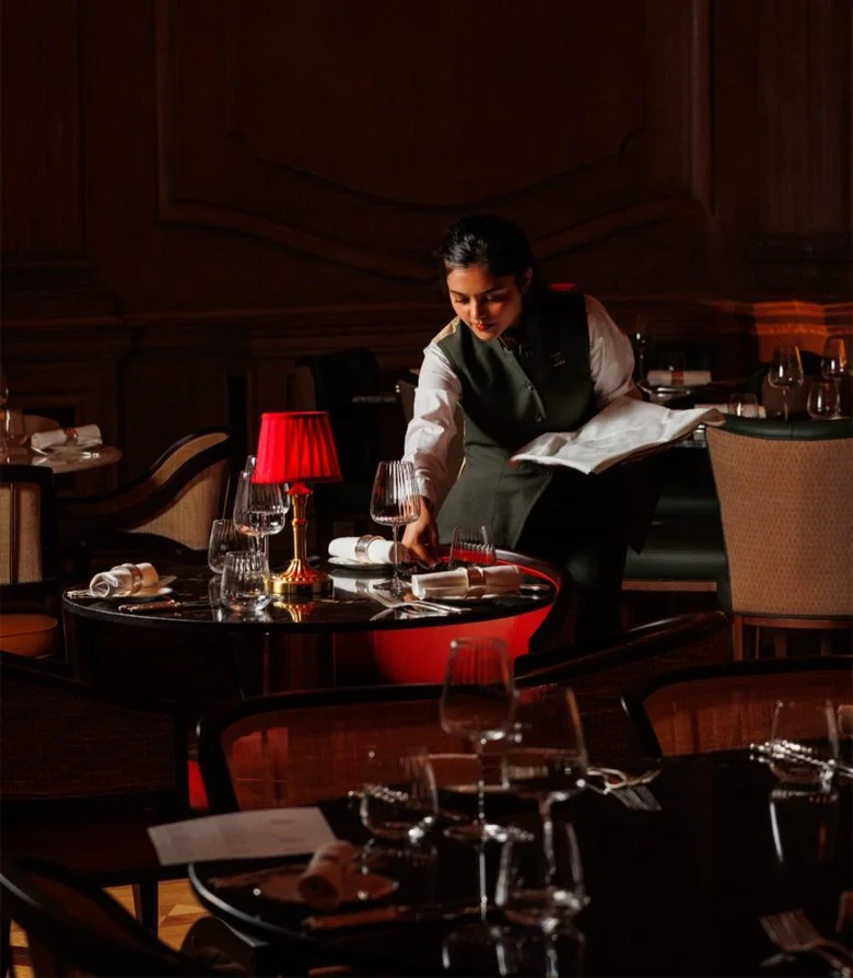 Waitress at Madhu's of Mayfair restaurant setting a table
