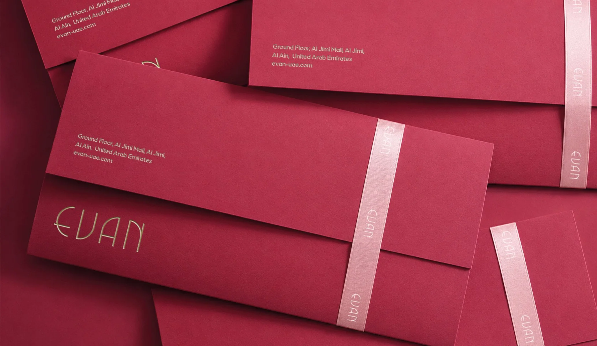 Magenta paper envelope with gold metallic foil details and a pink ribbon seal