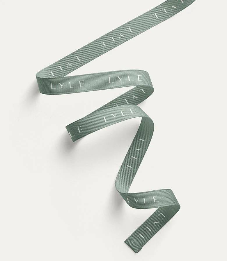 Green ribbon with the logo for Lyle Hotel in Washington DC repeated across it in white, designed by Colt