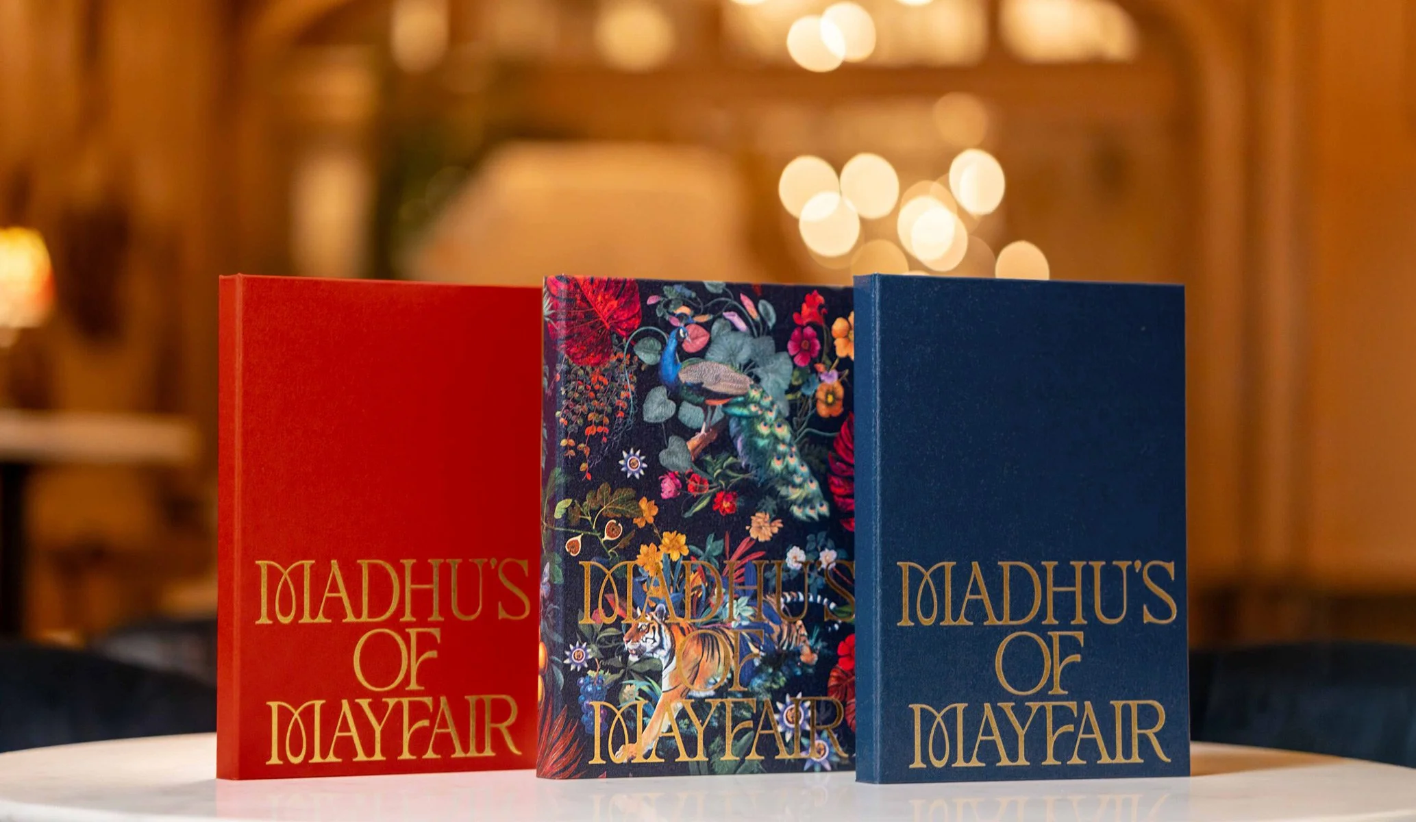 three menu folders in red, blue and custom illustration for Madhu's of Mayfair restaurant produced as part of the brand identity created by Colt