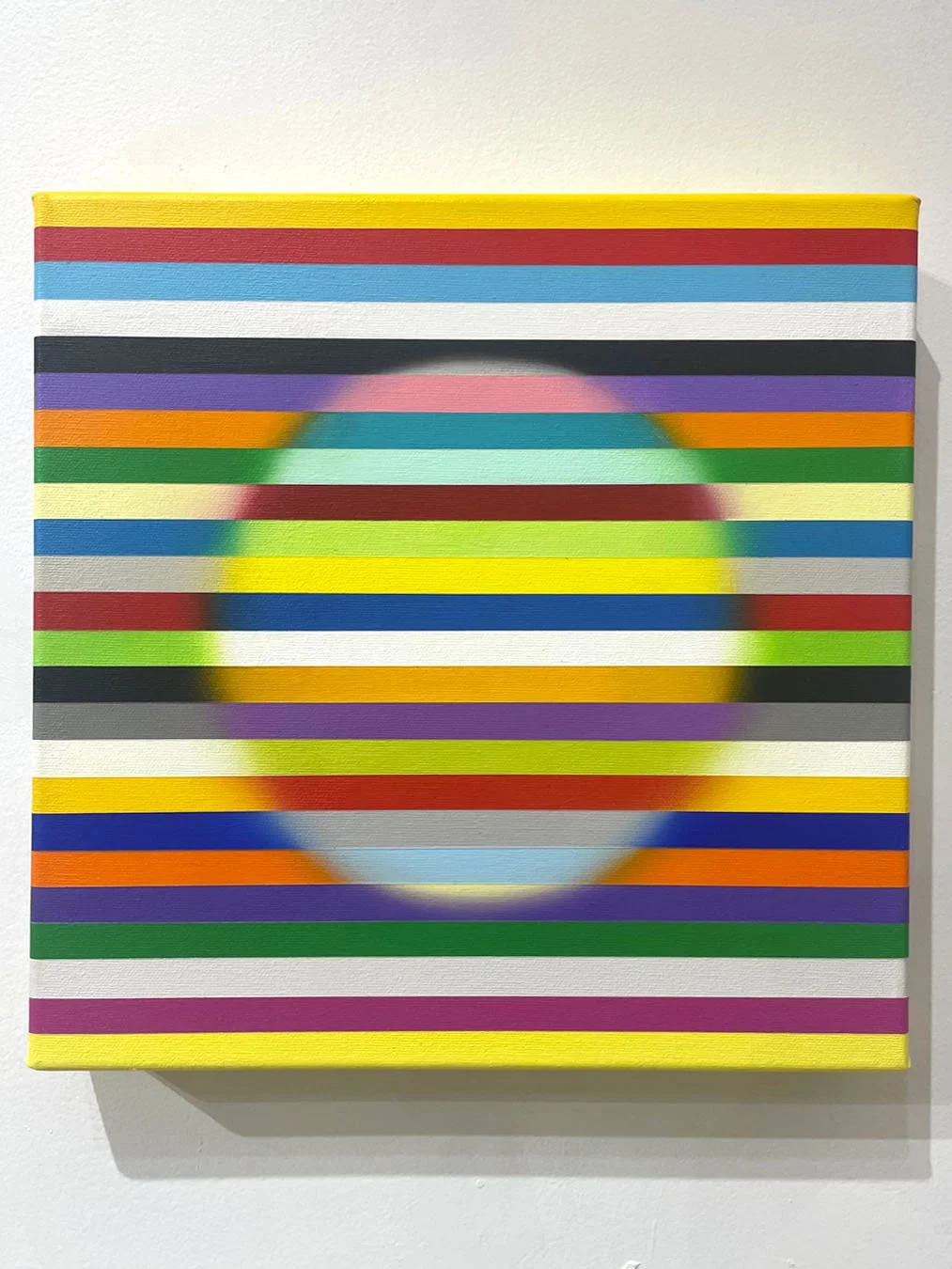 Abstract painting with horizontal multicoloured stripes forming a large softly blended circular shape