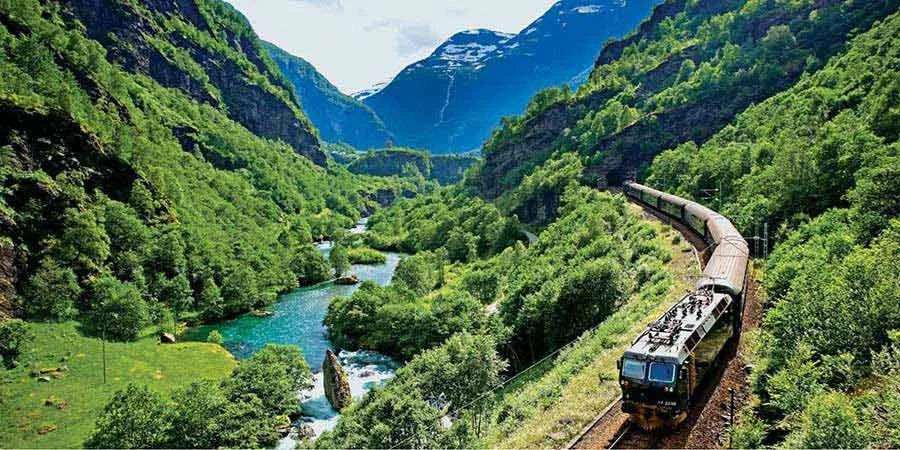 Scenic railway journey through Norway in summer with mountain views and lush landscapes
