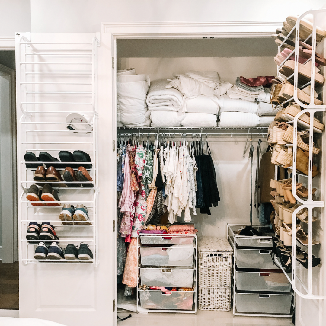 Closet with folded bedding on top shelf, hanging children's and adult clothing, shoe racks with various shoes, and shoe organizers on sides.