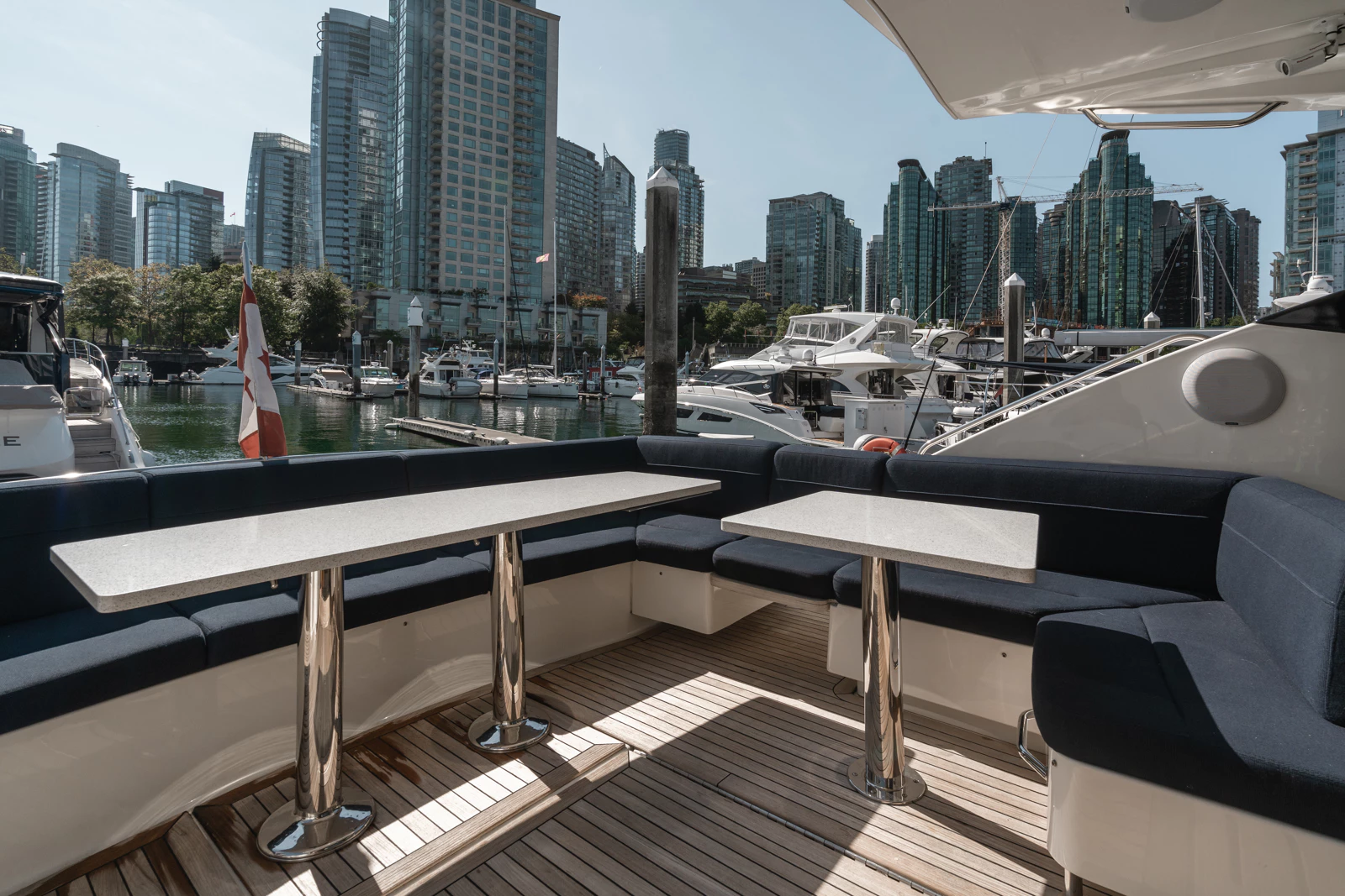 View from a yacht of a marina with boats and high-rise buildings in the background.