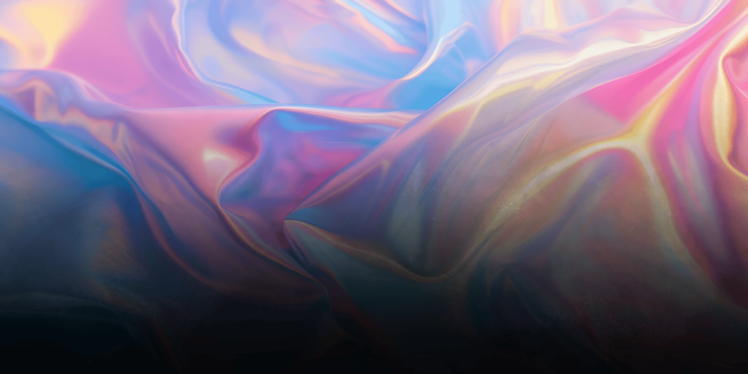 Abstract image of iridescent, multicolored fabric with soft folds and shimmering surface.