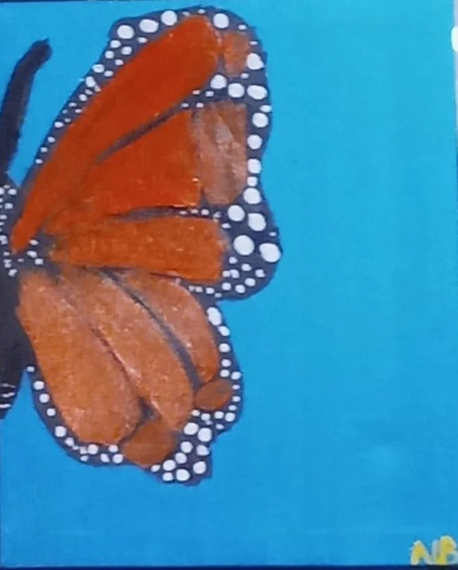 A close-up of a monarch butterfly with orange and black wings against a blue background.