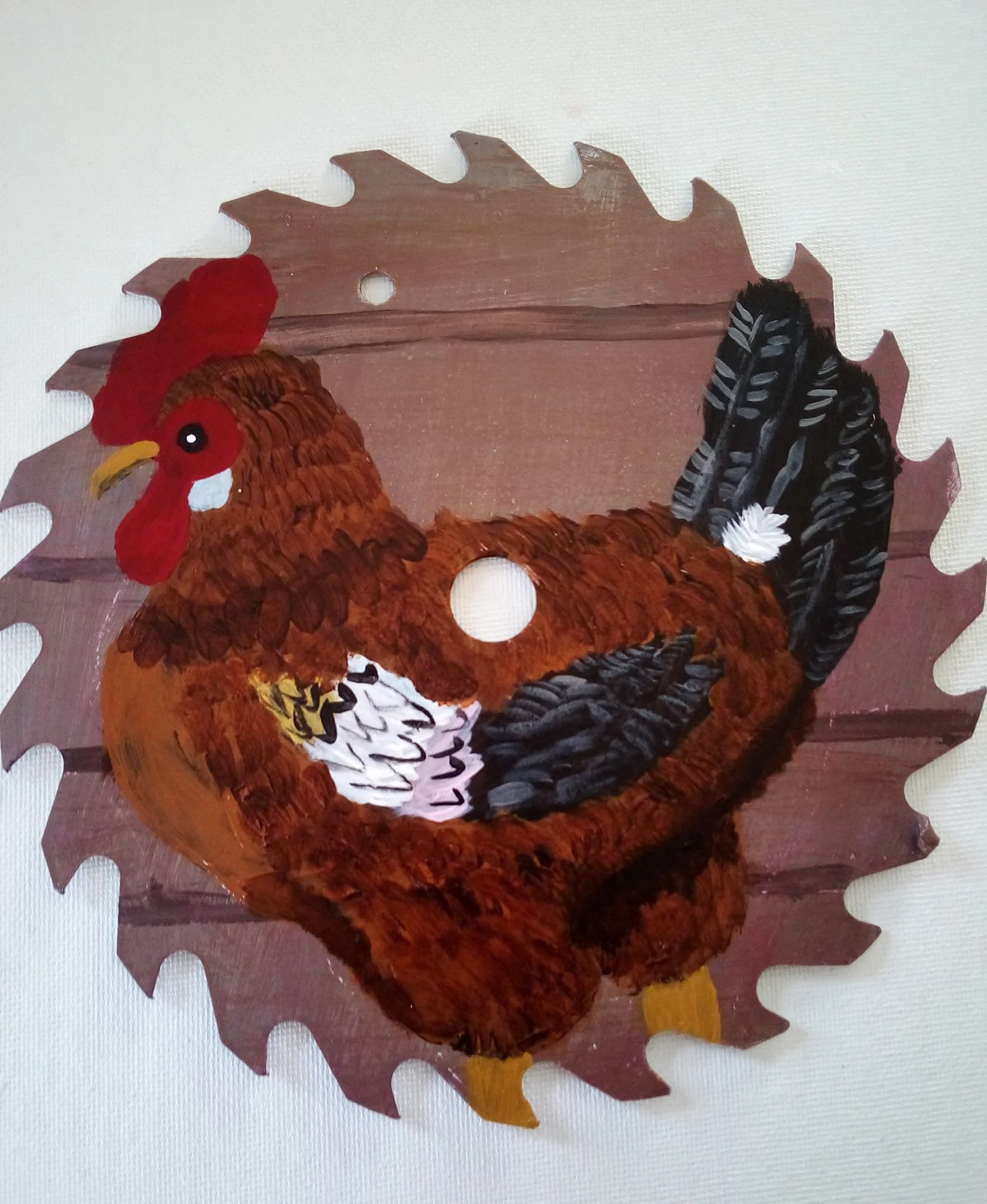 Crafted decorative turkey made with felt, feathers, and construction paper, with a background of a cardboard cutout resembling a leaf or feather shape.