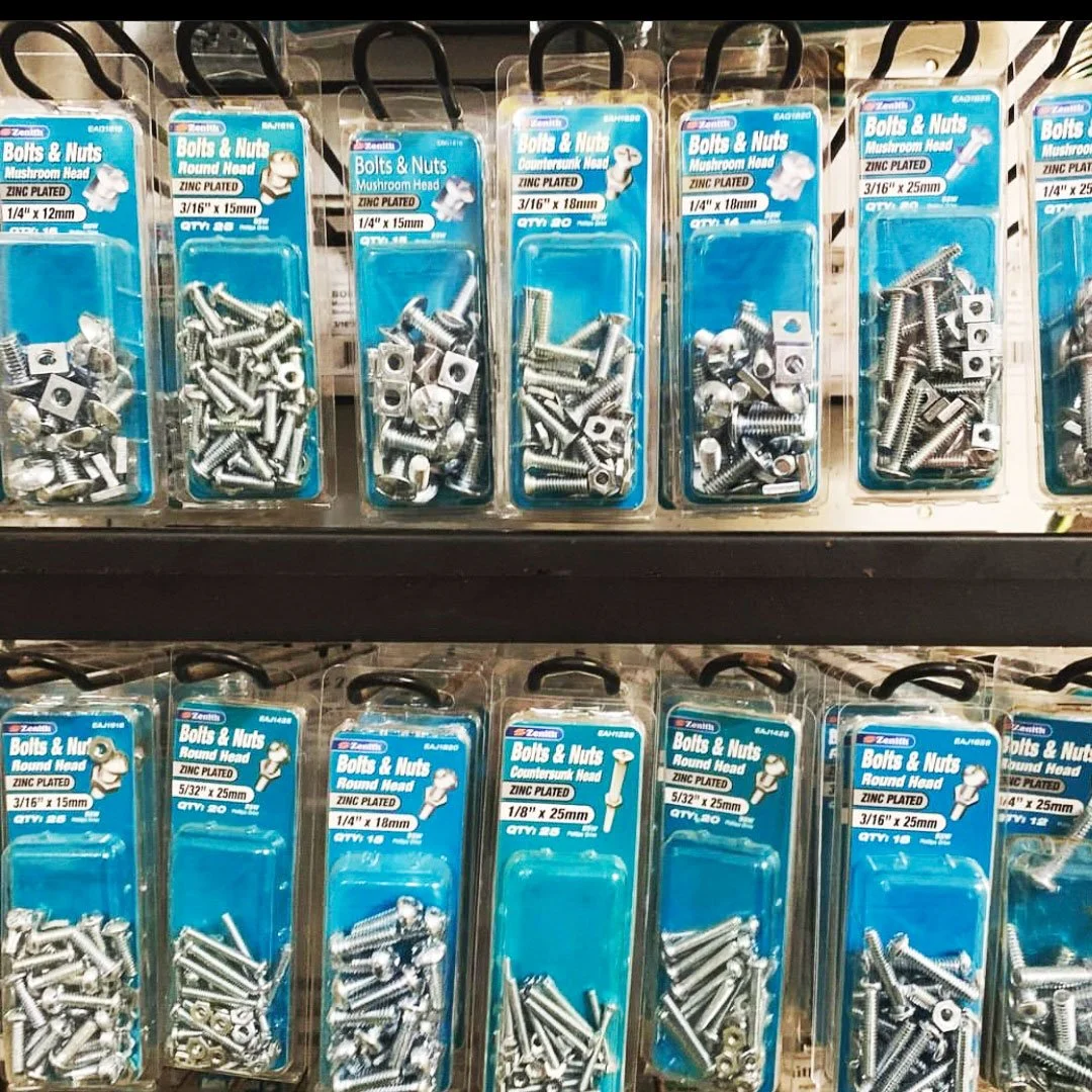 Packages of zinc-plated bolts and nuts displayed on a store shelf.