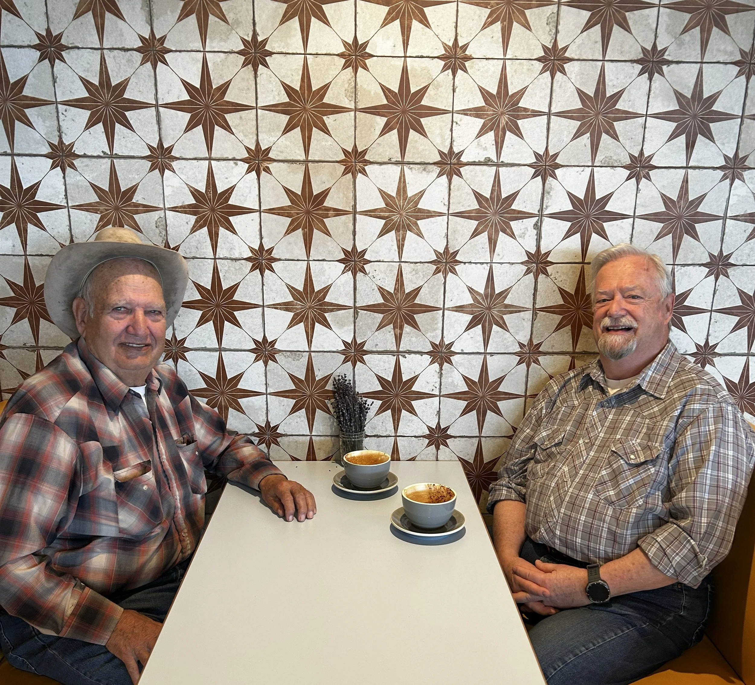 Two people sitting in a booth with coffee