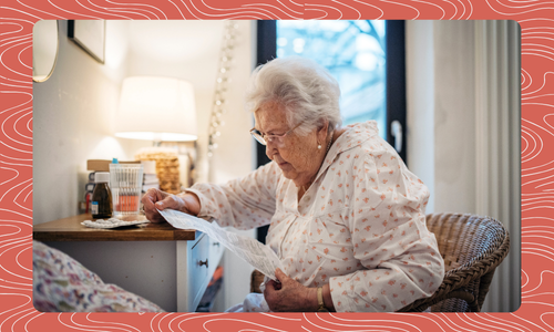 Older woman sitting in a chair reading instructions beside a bed