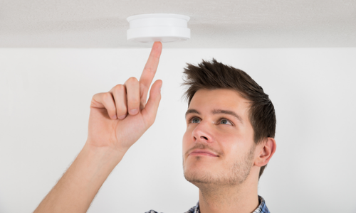 Man testing smoke detector