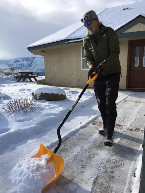 A person shoveling snow from a sidwalk