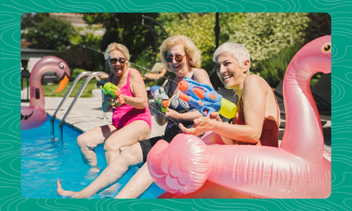 three people sitting pool side with squirt guns and inflatable flamingo pool tubes