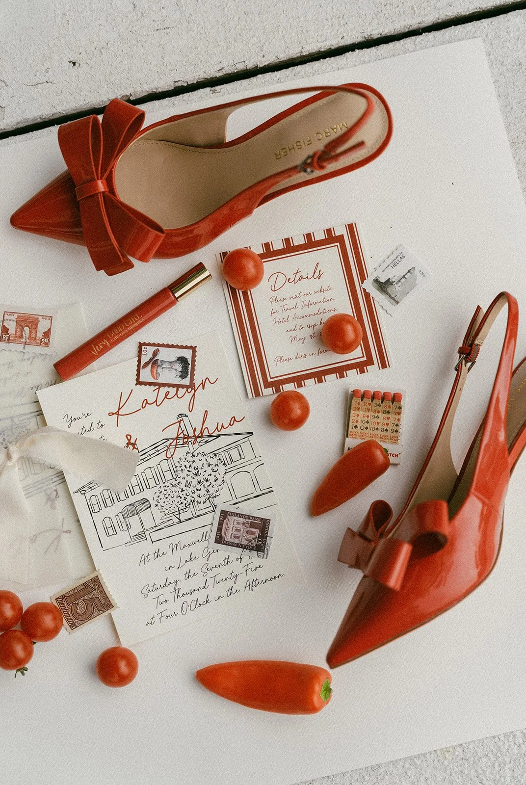 Red high-heeled shoes with bows, surrounded by red tomatoes, a red pepper, a lottery scratch ticket, postcards, a red lipstick, and vintage postage stamps on a white surface.