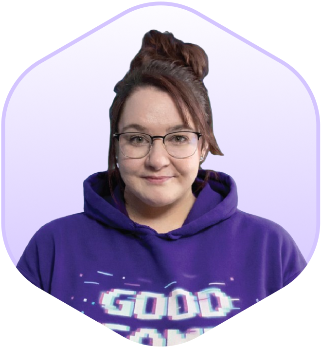 Therapist with shoulder-length brown hair, wearing a purple "Good Game Mud Club" T-shirt, against a digital, cube-like geometrical background in shades of blue and purple.