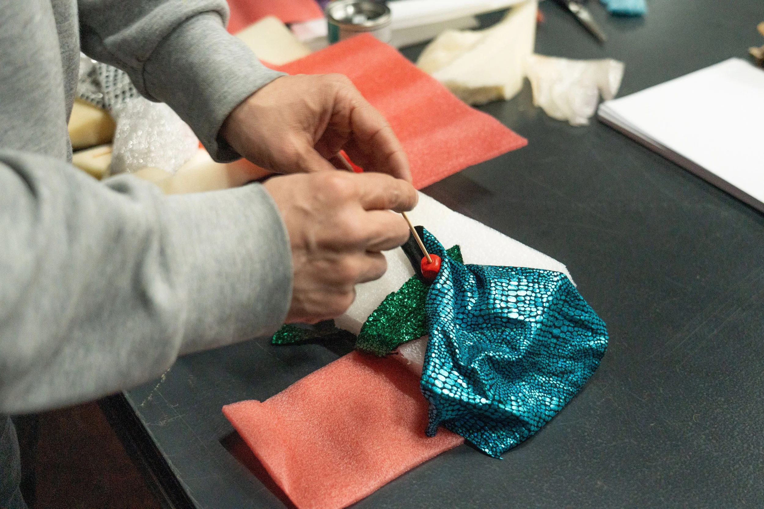 A pair of white hands crafting with fabric during a workshop