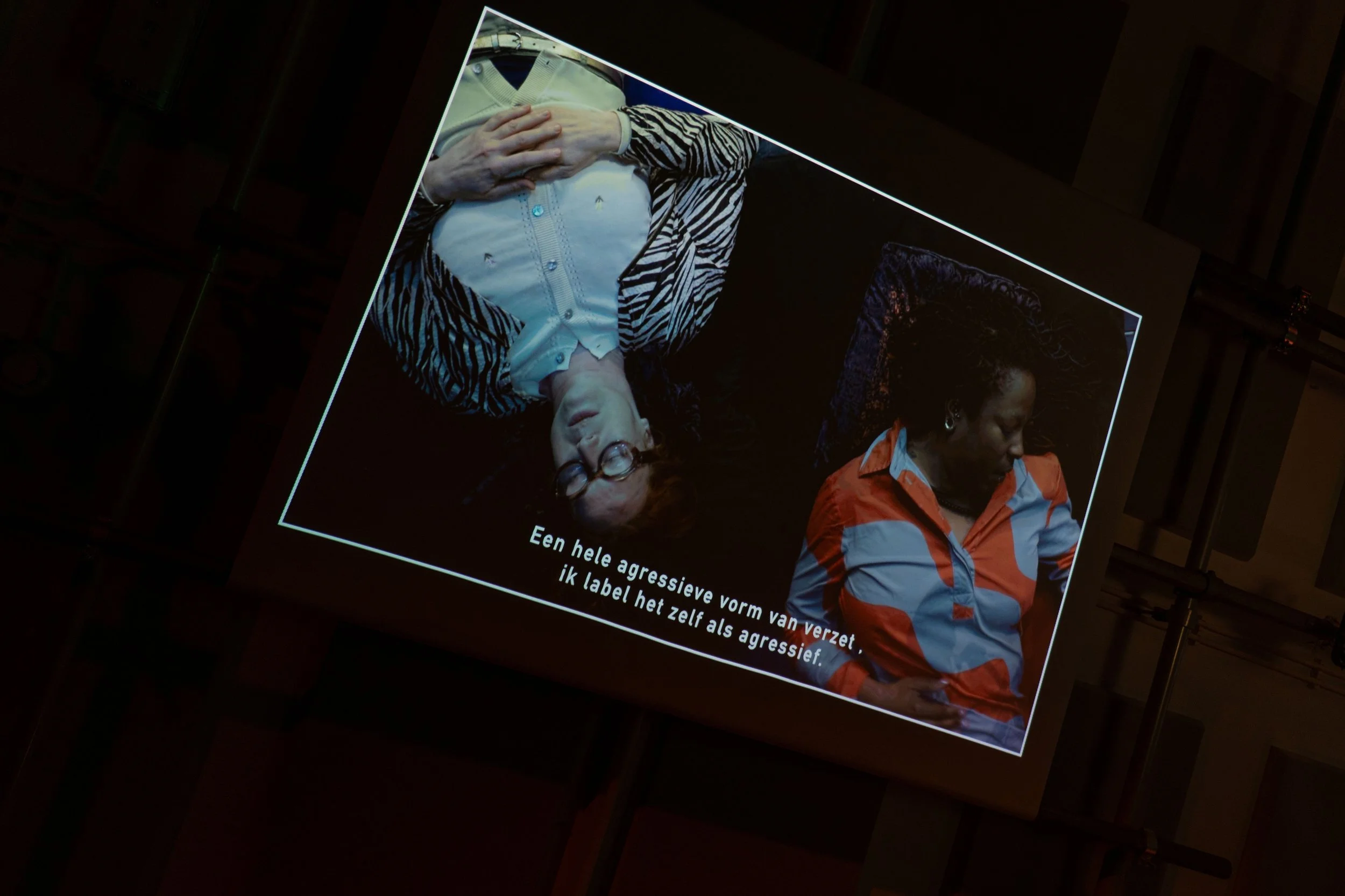 Viewing on a screen: Sandra Lange and a guest laying on the ground and talking to each other. This is a viewing of the podcast: no lemonade will be served here today