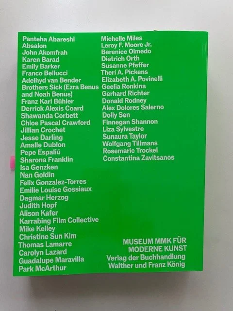 Bright green back cover thick art book, with white letters mentioning the Museum MMK für Moderne Kunst, and the names of all the artists whose work appears in this collection.