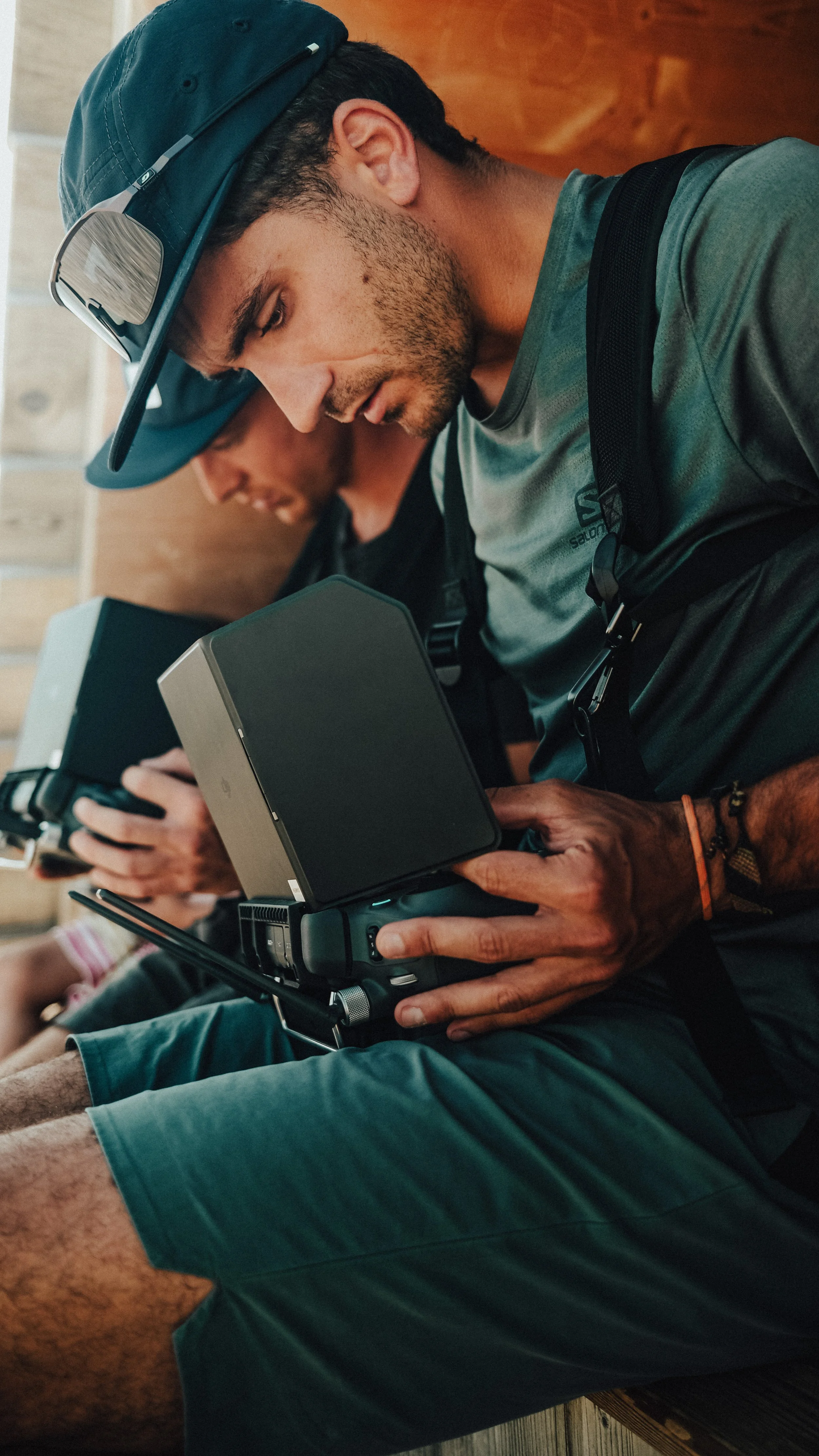 Robin Issartel - Outdoor Photographer and Film Director and drone operator sitting on a wooden bench using drone radios.