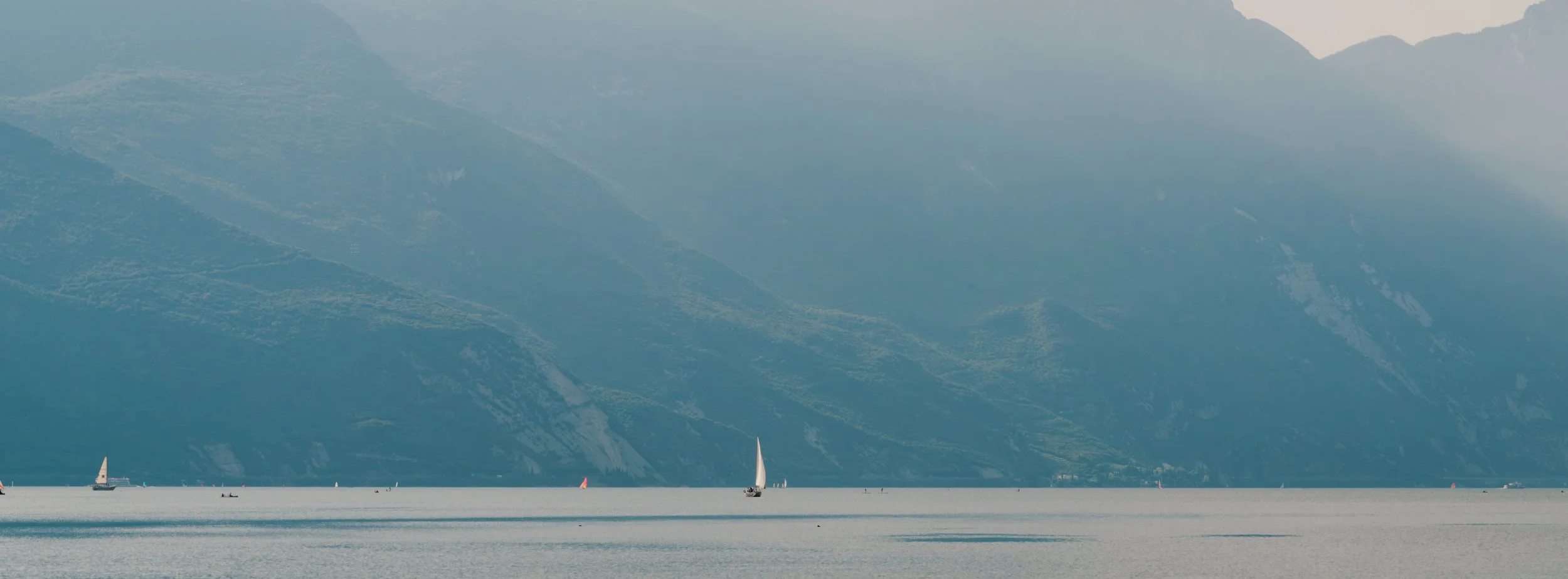 Panoramic shot of a sail boat on Lake Garda