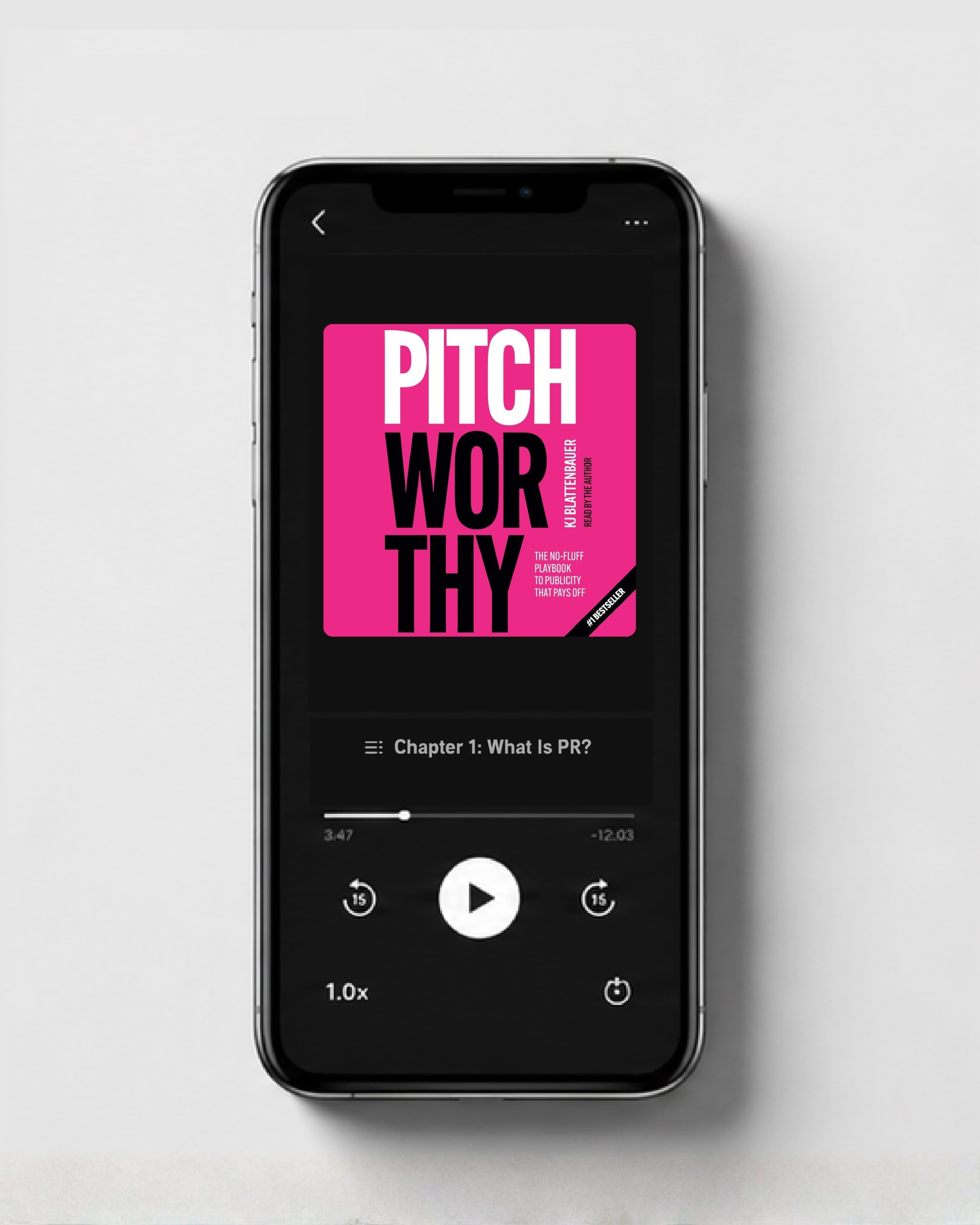 A smartphone displaying an audiobook app with a pink cover titled 'Pitchworthy' by KB Blattenbauer, showing the chapter 1 titled 'What Is PR?' with playback controls.