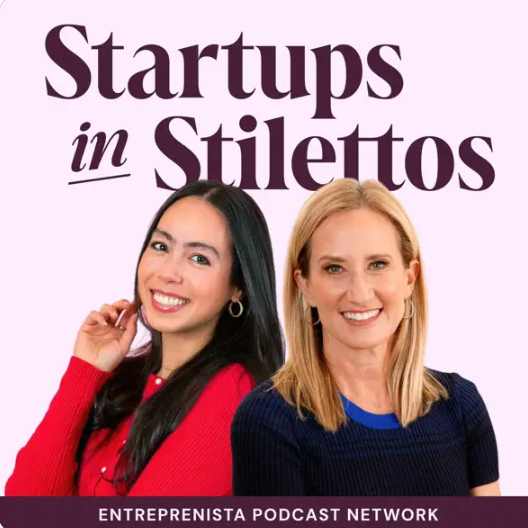 Two women smiling, one with long dark hair wearing a red sweater and the other with shoulder-length blonde hair wearing a dark blue sweater, sitting against a light purple background with the text "Startups in Stilettos" and "Entrepreneurista Podcast