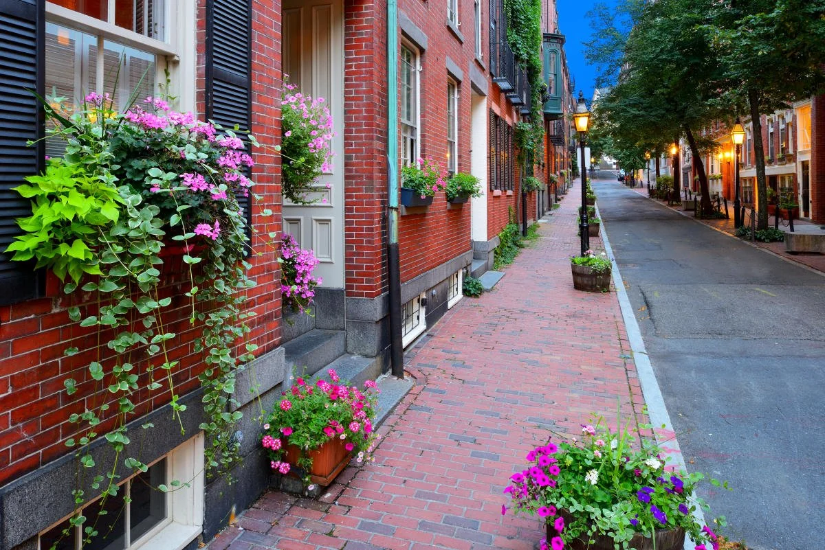 Charming brick sidewalk with flower boxes, residential street, evening lighting