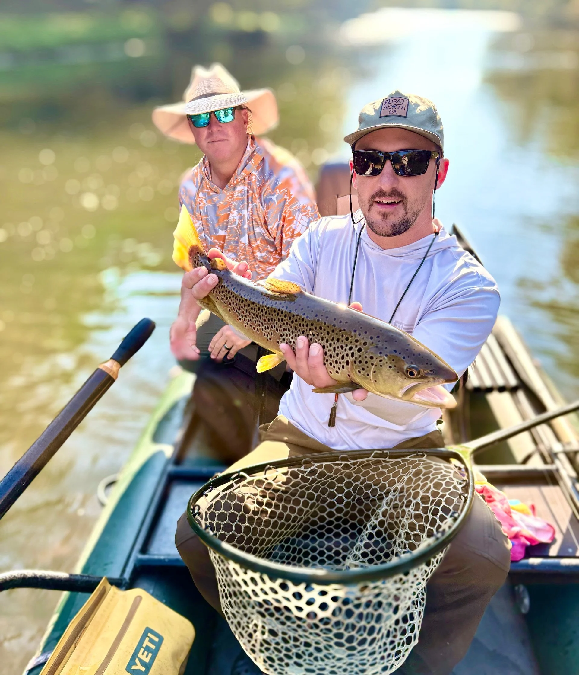 Fly Fishing guide holding a beautiful brown trout on the water in Blue Ridge Georgia