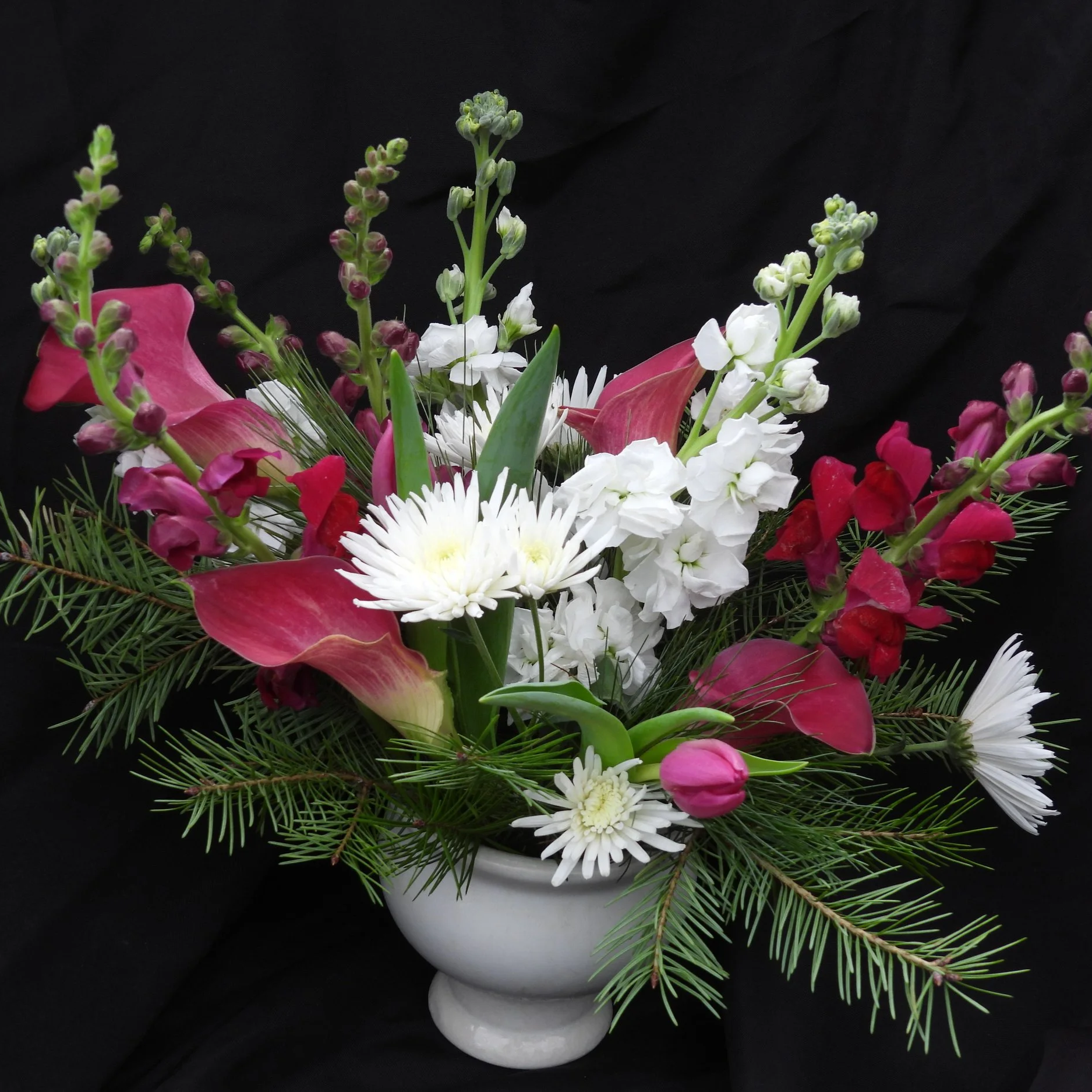 Winter white and pink arrangement with evergreens