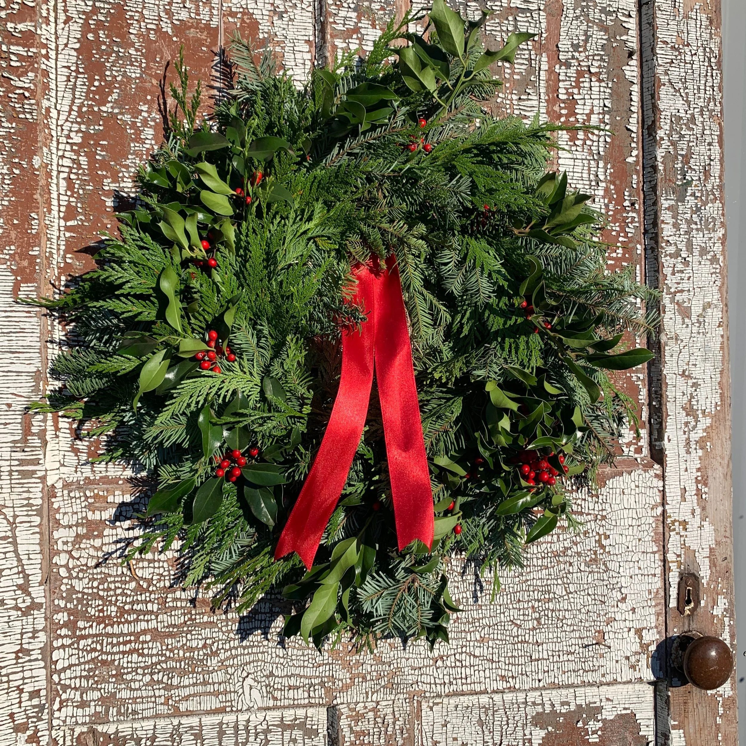 Evergreen wreath with red ribbon and berries