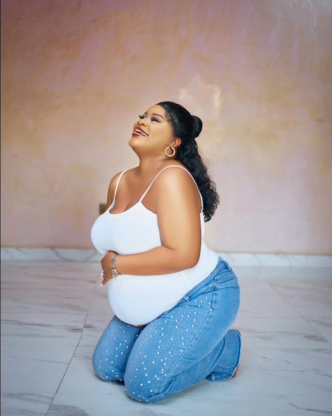 A pregnant woman is smiling. She is emotionally and mentally prepared for her growing family and postpartum experience because of therapy. Find confidence in your postpartum journey in Cedar Rapids, Des Moines, or virtually in Iowa!