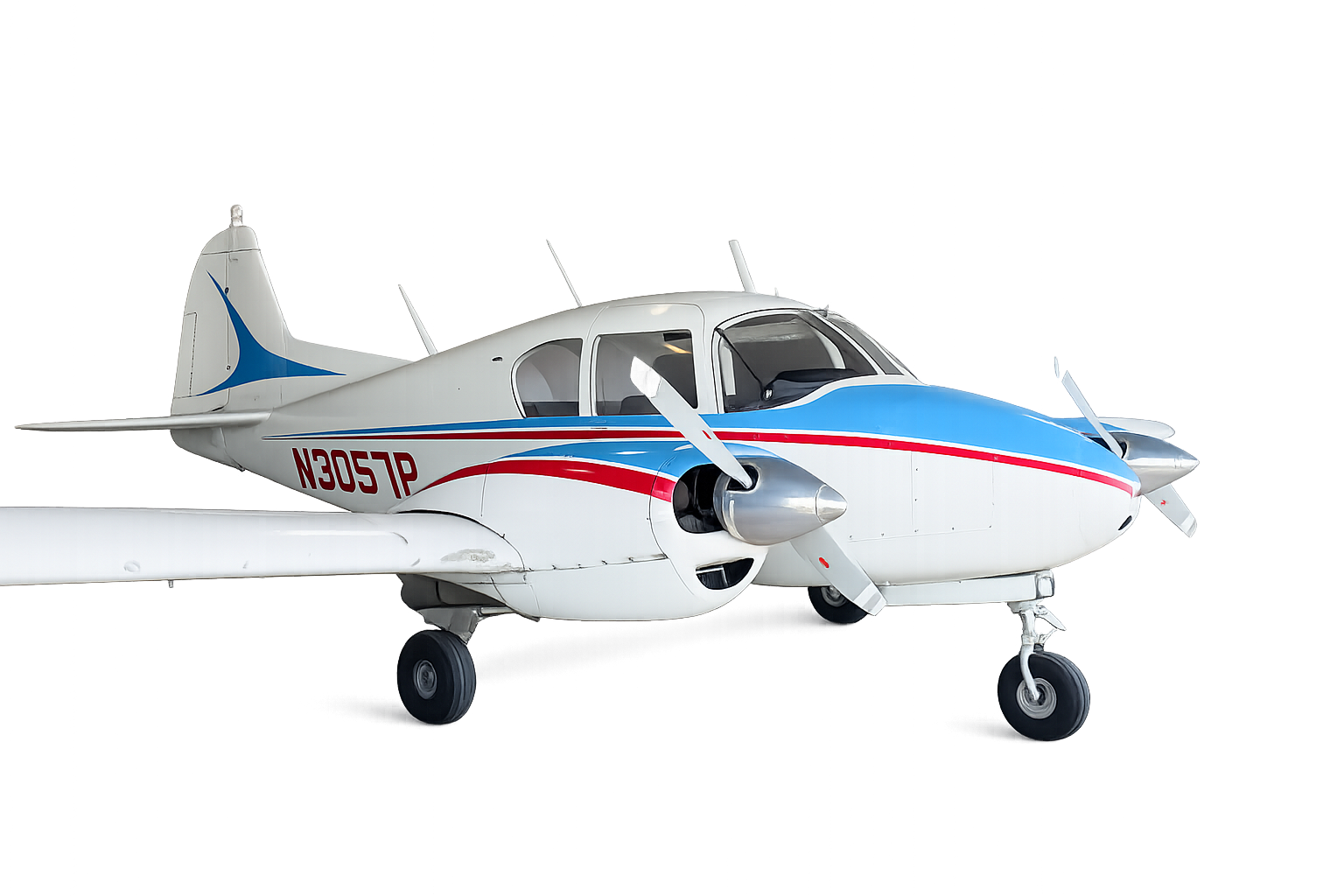 Small private jet with white, blue, and red accents on tarmac at night, illuminated by lights.