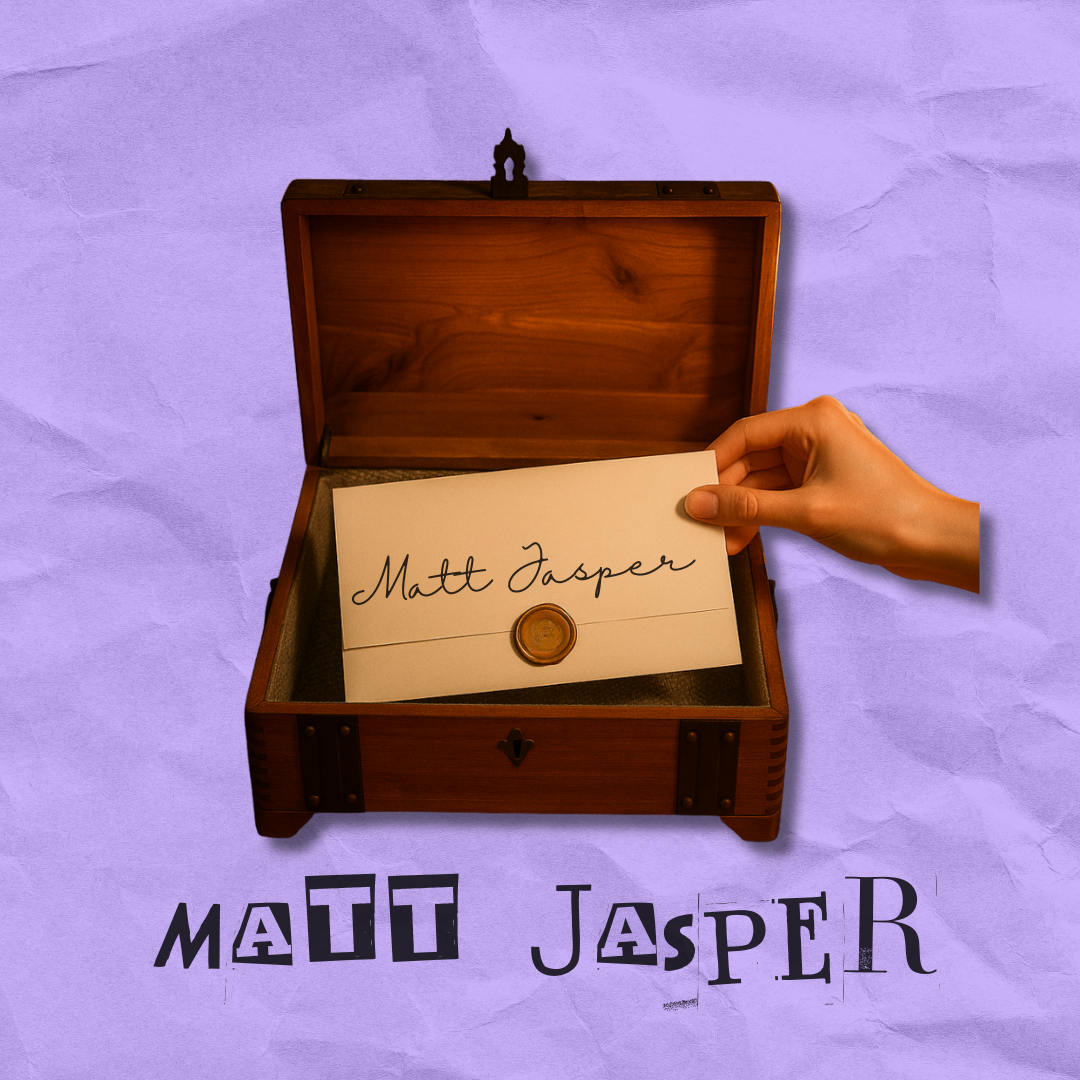 A hand holding a piece of paper with the handwritten name 'Matt Jasper' inside an open wooden box on a purple textured surface. The paper features a gold wax seal, and the name 'Matt Jasper' is written in cursive.