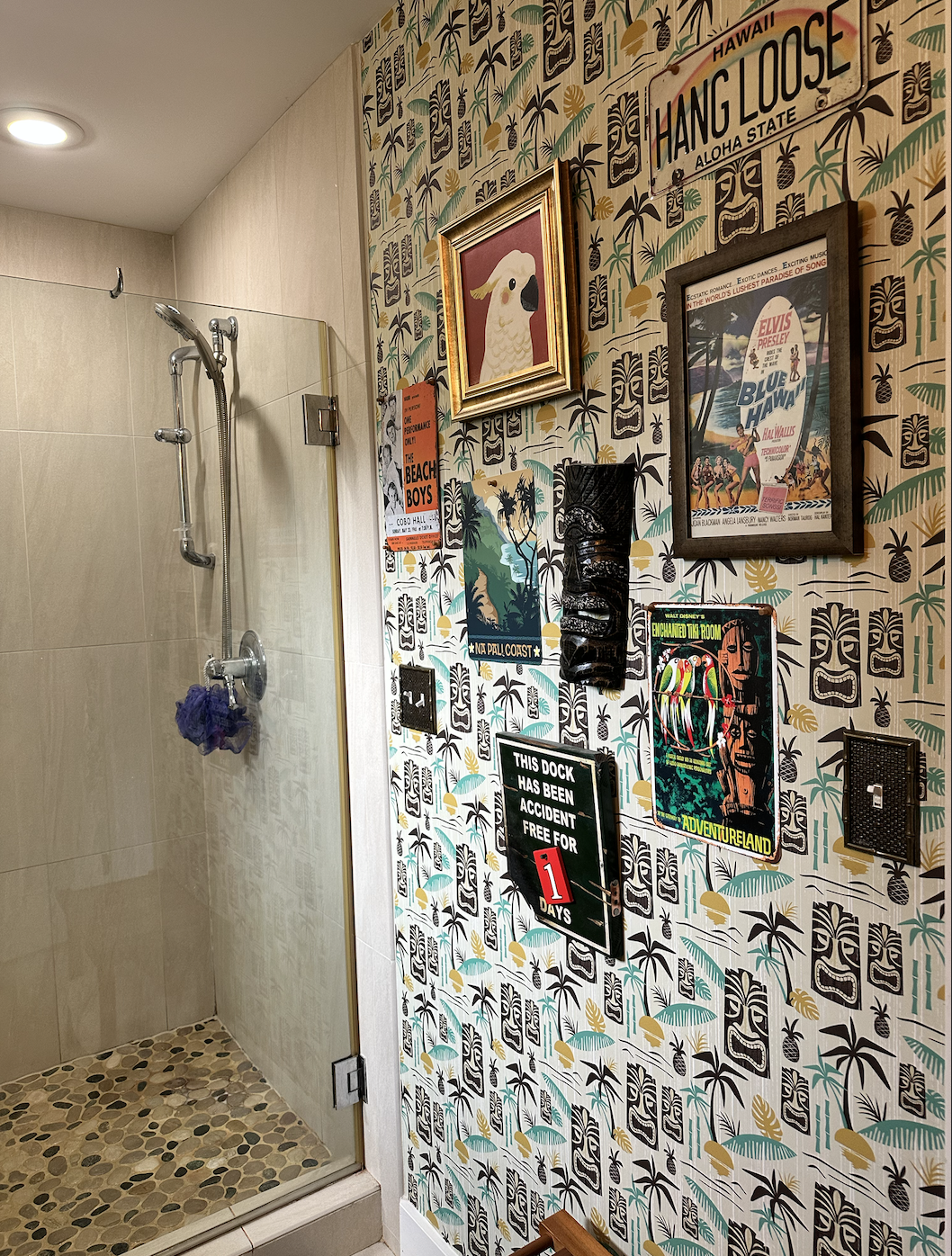 AFTER: the browns in the wallpaper and some of the artwork hanging here draw out the browns and tans in the pebbled floor of the shower