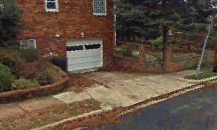 BEFORE: The old, broken garage door and crumbling brick retaining wall